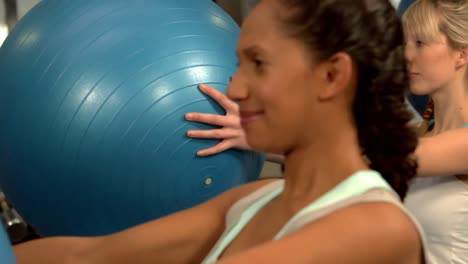 Women-holding-exercise-balls-up-with-their-hands