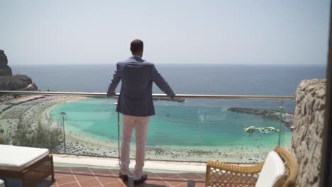 a man goes to the balcony with ocean view