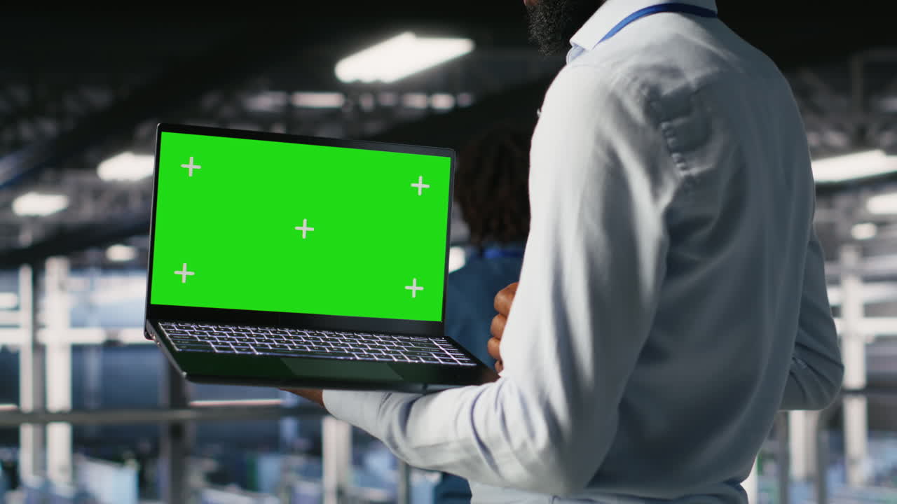 Close up of engineer on data center using green screen laptop