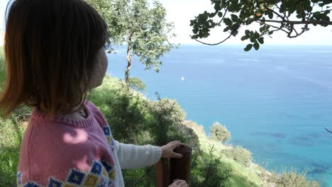 Close-up-profile-of-a-little-girl-looking-out-over-the-coast-of-Cyprus-at-the-blue-Mediterranean-sea