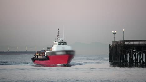 un remolcador llegando a atracar en el puerto en una noche brumosa