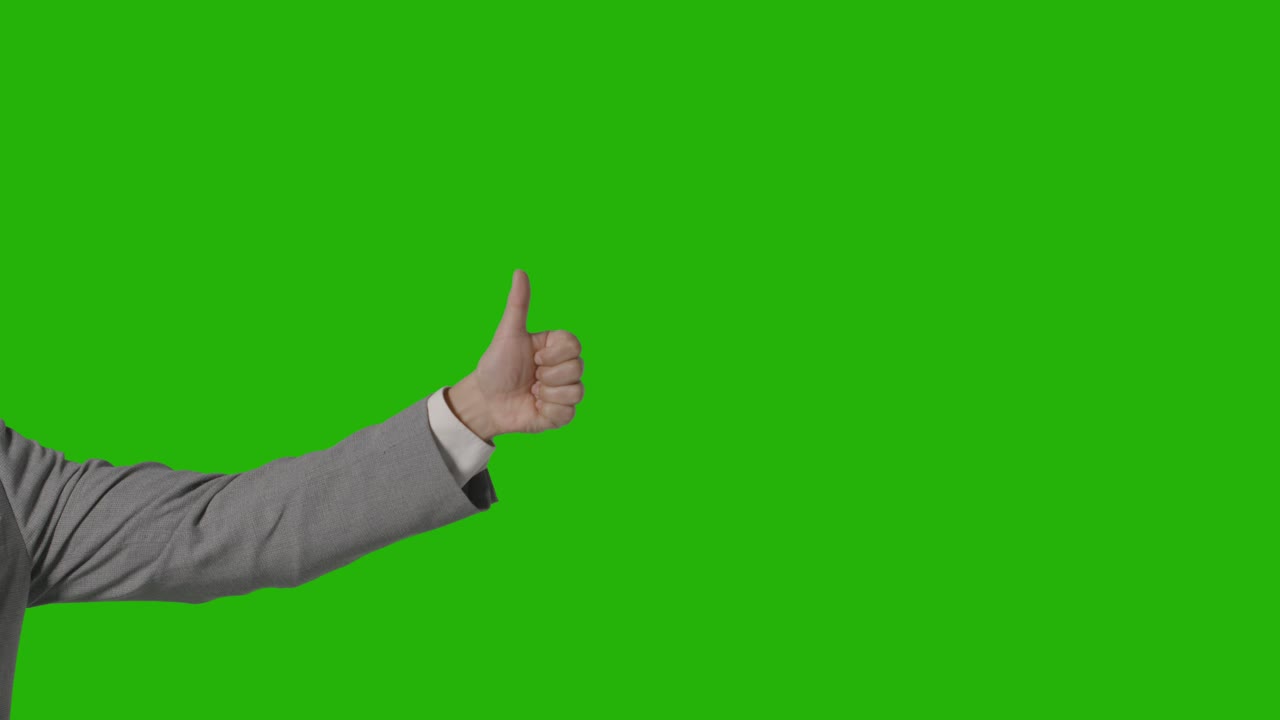cerca del brazo del empresario en traje dando thumbs up gesto contra la pantalla verde