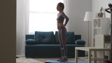 la mujer está entrenando las piernas con cinta de fitness para trabajar los músculos entrenamiento en casa perder peso y mantenerse en forma práctica concepto de bienestar