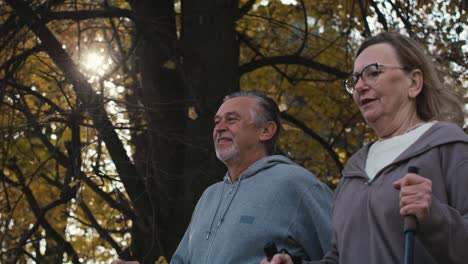 caucasian senior couple nordic walking in the park