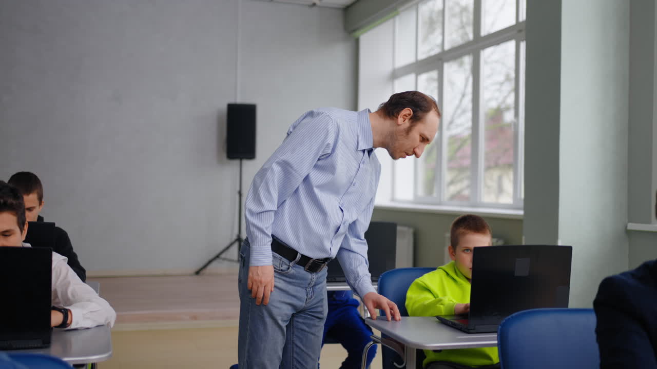 Lærer hjælper elever i en computertime