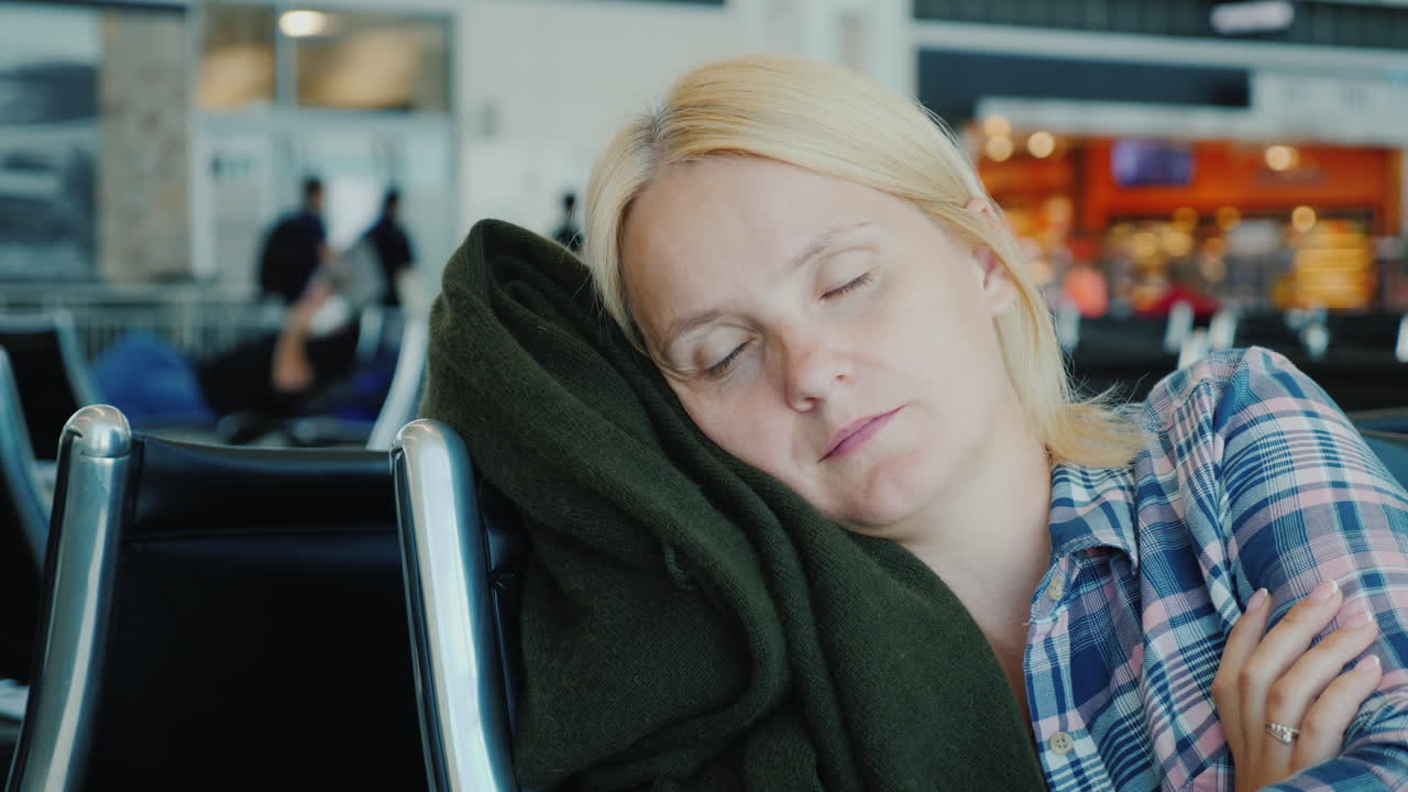 pasajero cansado duerme en la terminal del aeropuerto mientras espera su vuelo