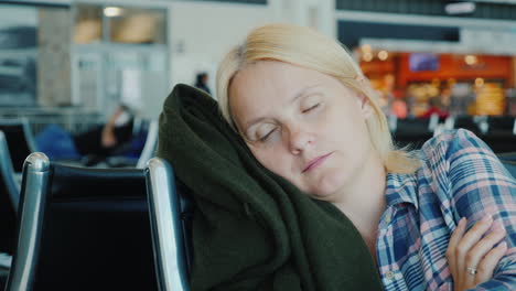 tired passenger sleeps in airport terminal while waiting for his flight