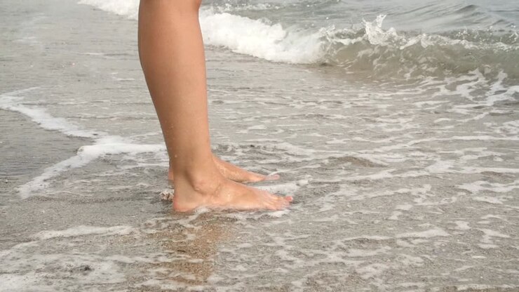 Waves Breaking Over Ladies Feet