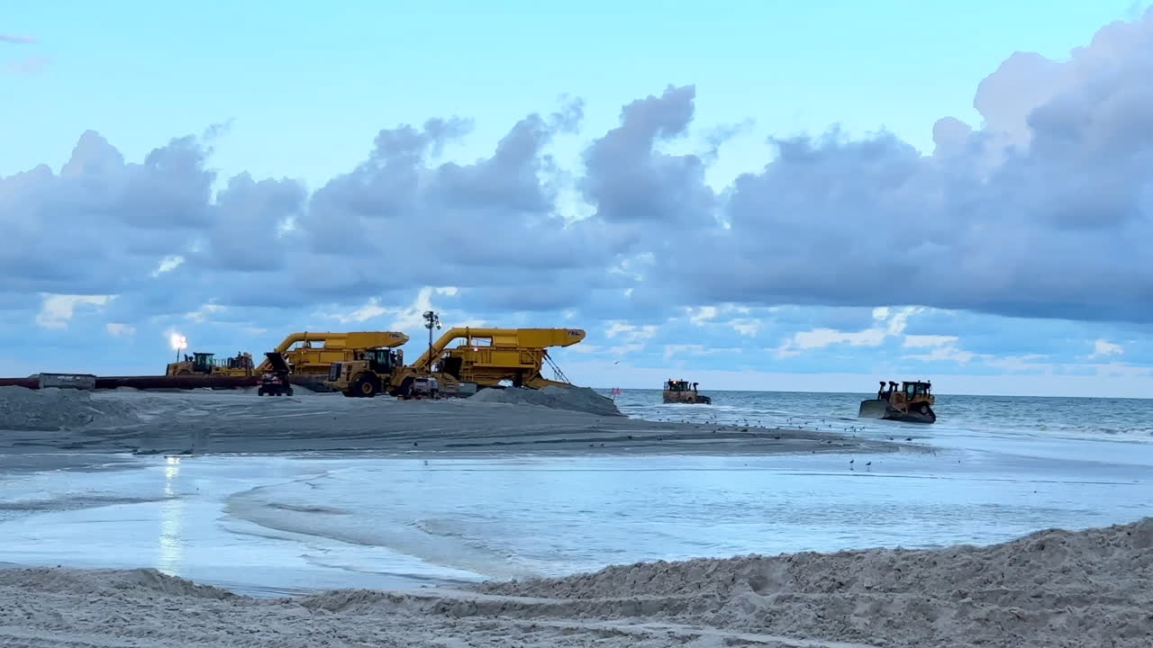 Beach Restoration Project: Heavy Machinery Moving Sand on Shoreline