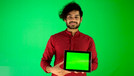 guy using mobile - tablet with green screen and green background indian guy with green screen