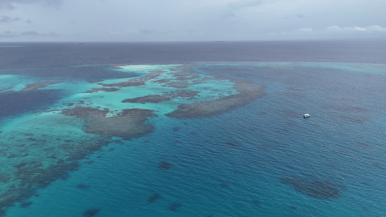 Riprese aeree con drone di barriera corallina e laguna turchese alle Maldive tropicali.