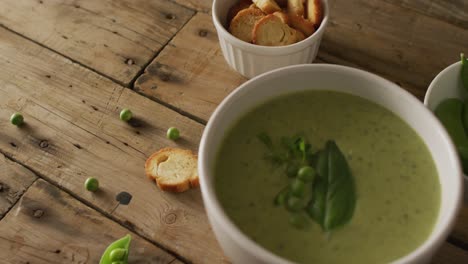 video of green peas soup and ingredients lying on wooden surface