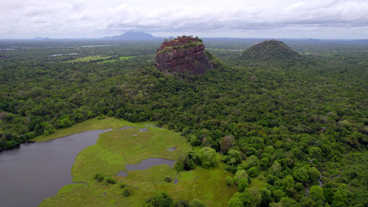 Sigiriya Rock citadel standing above expansive forest canopy