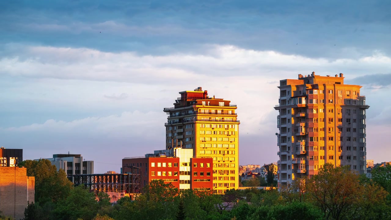 Time-lapse de um horizonte urbano contemporâneo iluminado pela luz quente do sol da hora dourada, refletindo em edifícios residenciais e comerciais modernos.