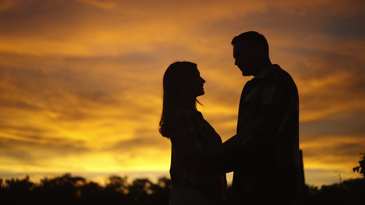 일몰 에 있는 만적 인 부부 의 실루