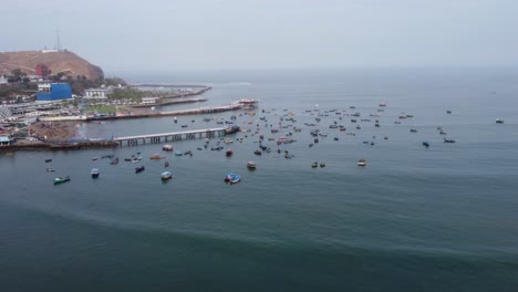 imágenes de drones, volando hacia adelante desde la playa hacia un puerto con muchos barcos de pesca y 2 muelles