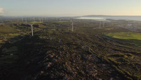 Vista-Aérea-Estática-De-Drones-De-La-Granja-De-Turbinas-Eólicas-A-La-Hora-Dorada,-Vasto-Paisaje