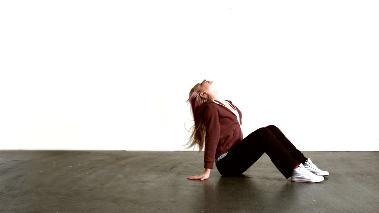 운동적인 금발이 머리카락을 던지고 있습니다.