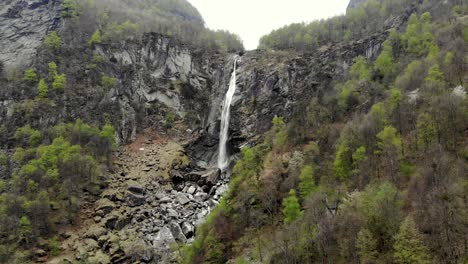 aerial view of foroglio in ticino, switzerland with reverse motion away from the waterfall over the old stone house rooftops of the village