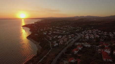 Aerial-view-of-coastal-resort-town-with-cottages-on-the-shoreline-Greece