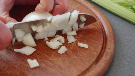 close up and slow motion of chopping an onion in tiny cubes