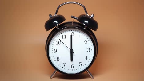 reloj despertador vintage negro con dos campanas en fondo marrón