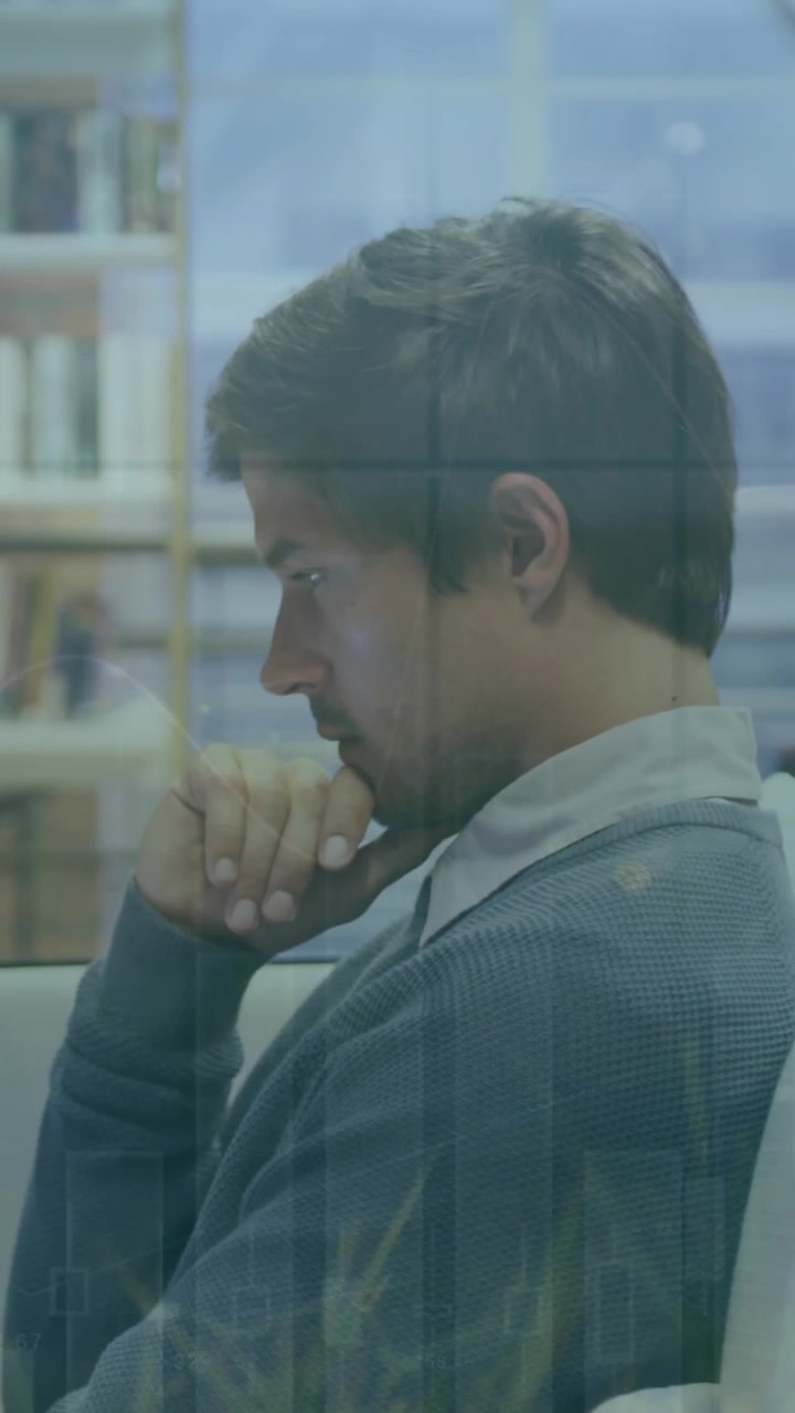 Animazione di più grafici e foglie su un uomo d'affari caucasico concentrato che lavora al laptop