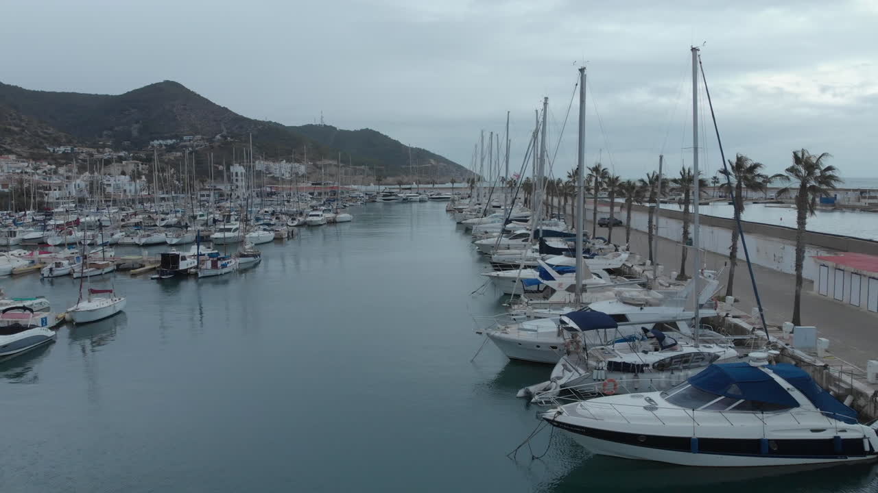 il drone cattura gli yacht attraccati vicino alla città costiera con lo sfondo delle montagne