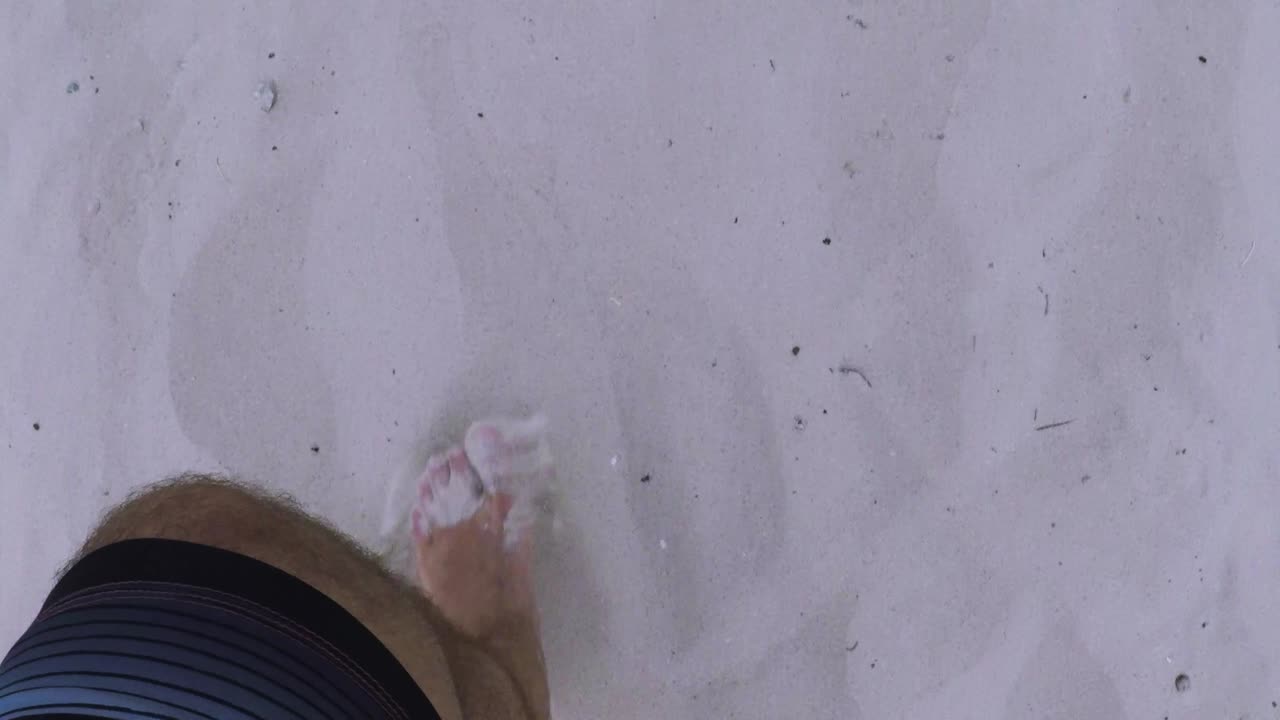 모래 해변에서 걷는 남자