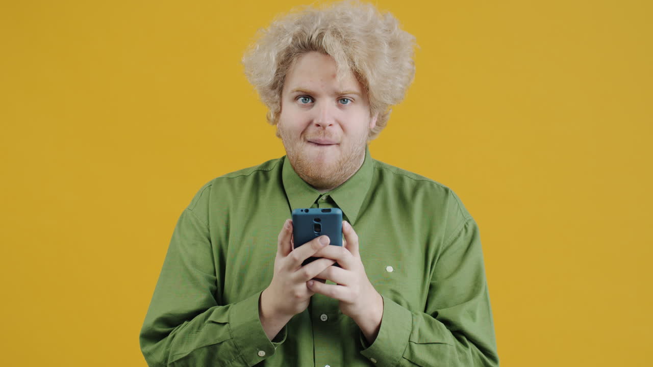 Uomo che guarda il cellulare con espressione sorpresa