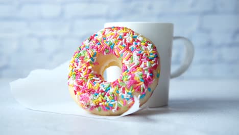 colorful sprinkled donut with coffee cup