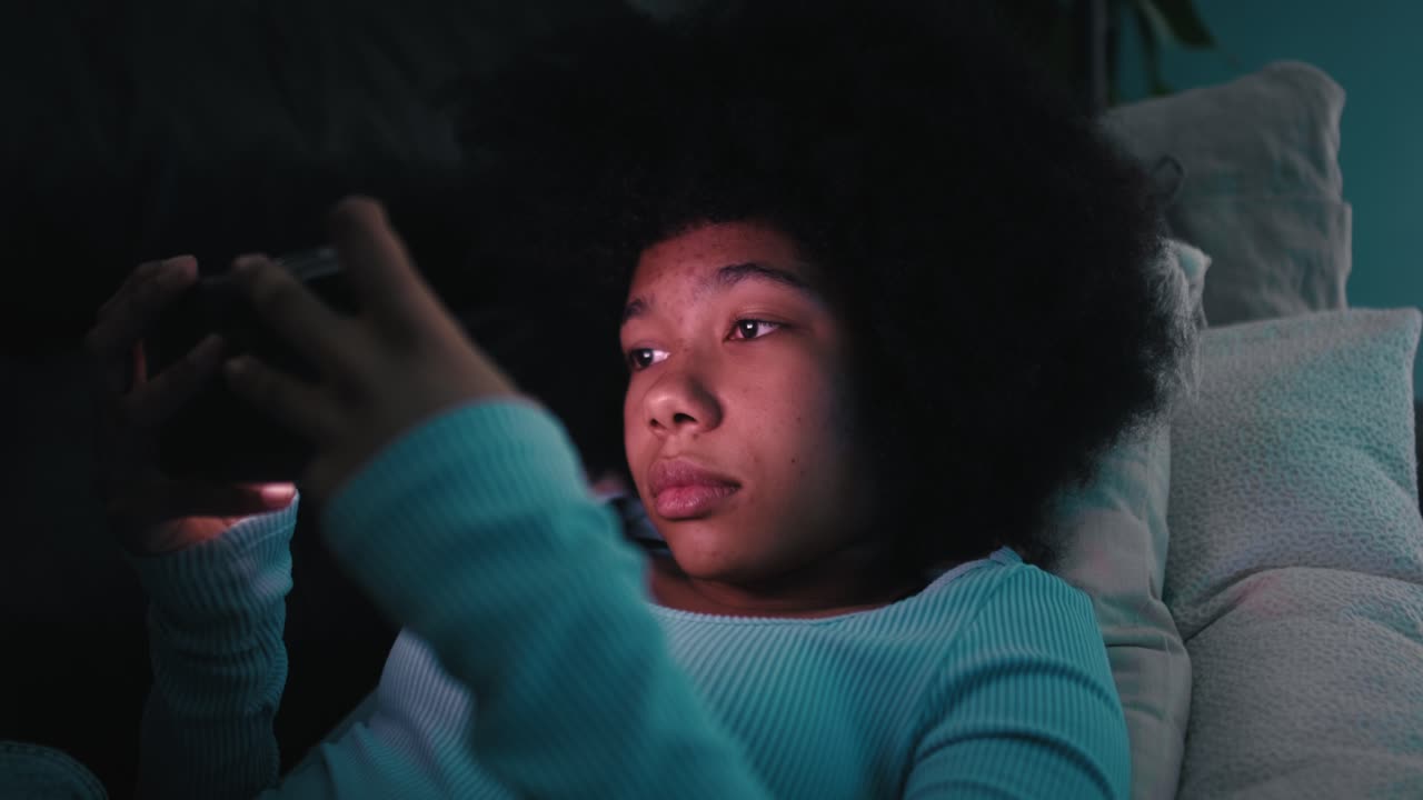Teenage girl browsing mobile phone in the living room at night