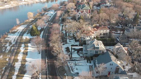 aerial footage following a car on a nice neighborhood, road by the lake shores during a sunny afternoon