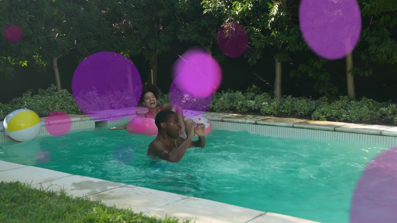 Woman floating on pink donut pool man jumping causing splash tossing ball playing leisure overlays