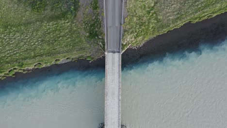 bridge crossing main stem river mixing with tributary in iceland, confluence