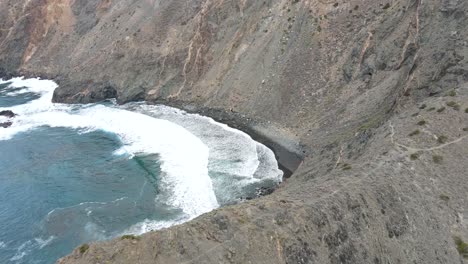 Asombrosas-Imágenes-De-Drones-De-Playas-De-Arena-Negra-Y-Olas-De-Espuma-Salpicando-Contra-La-Orilla-En-La-Empinada-Costa-De-La-Gomera,-España