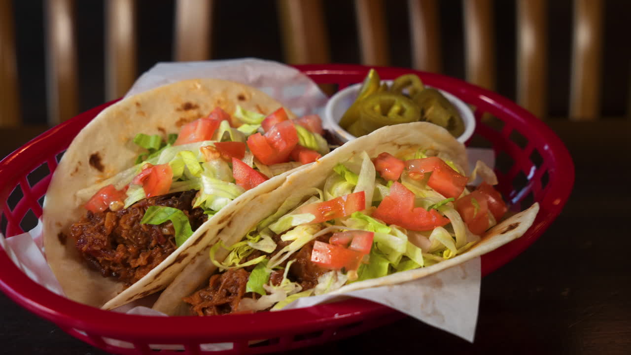측면에 절인 할라피뇨가 있는 밀가루 토르티야에 쇠고기 소프트 타코의 테이블탑 샷, 슬라이더 4k