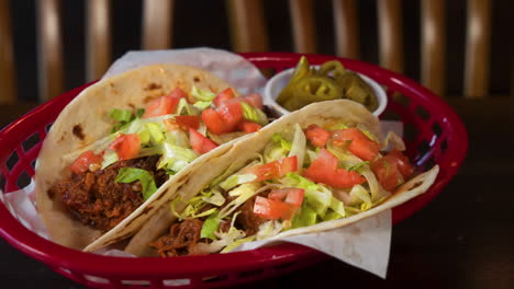 tabletop shot of beef soft tacos in flour tortillas with pickled jalapenos on the side, slider 4k