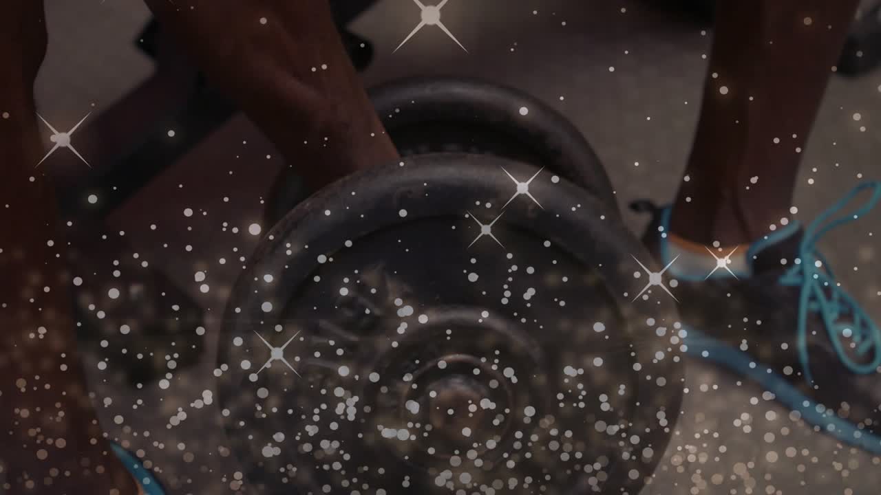 Male trainee gripping dumbbell and pressing up on bench, sparkle overlaying scene, building fitness