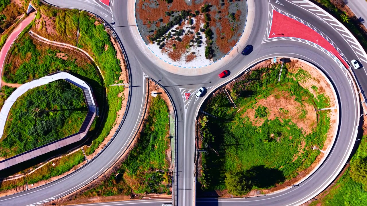 Bridge crossing over a multilane motorway with green landscape around. Top down aerial view of highway overpass and traffic lanes.