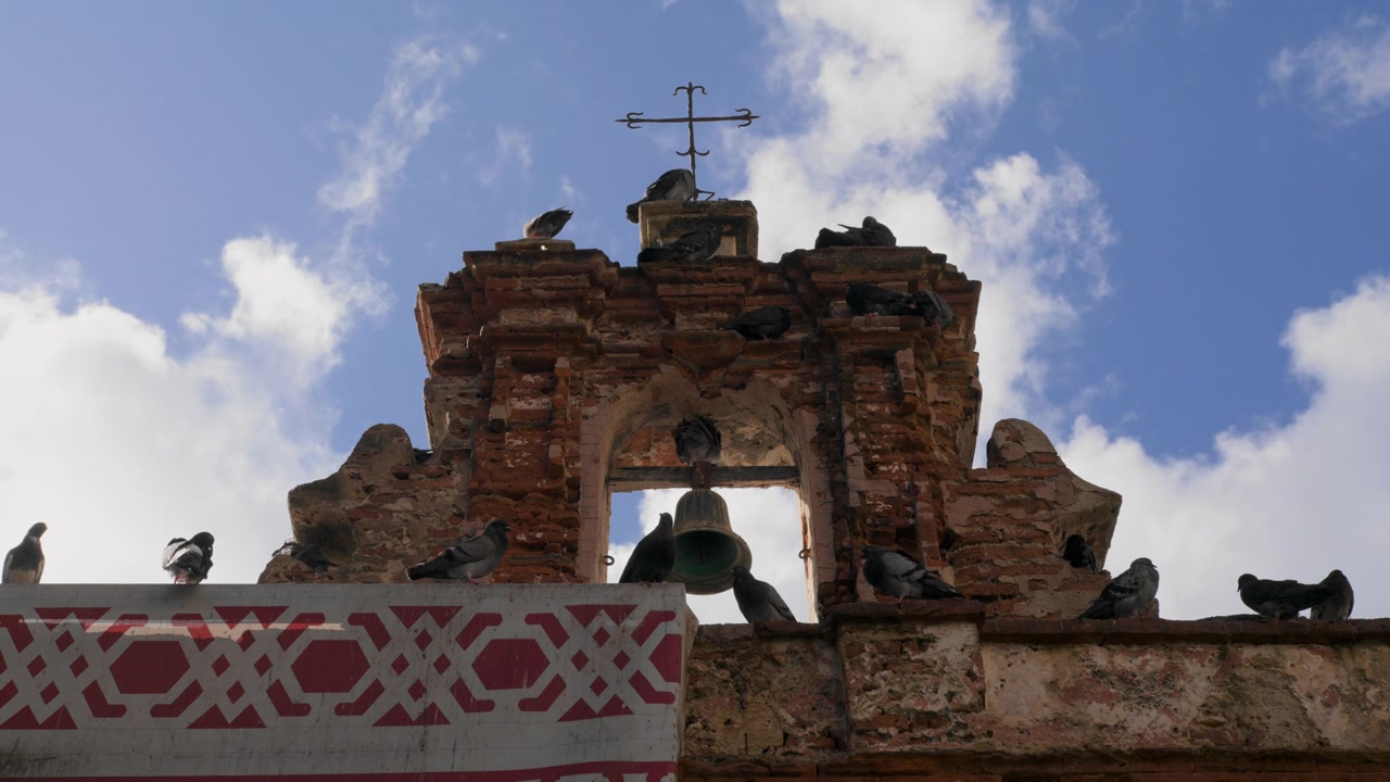 Duene sitter på klokketårnet til historiske Capilla del Cristo i gamle San Juan, Puerto Rico - Skyer passerer - Låst av - UHD 4K