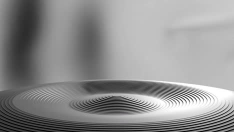 animation of grey ridged circular podium rising and falling on blurred background