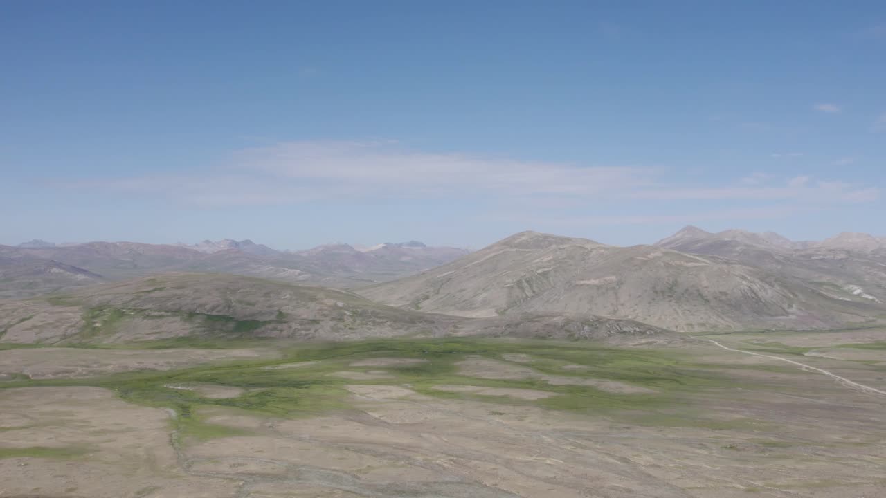 Deosai Plains with rolling hills and scattered green patches. Gilgit-Baltistan