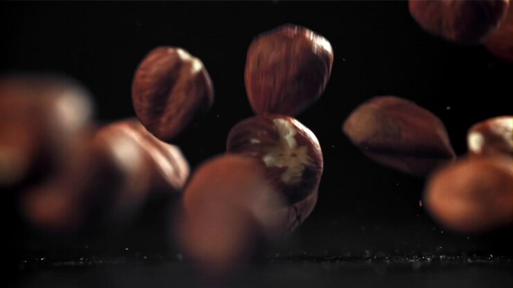 Hazelnuts Falling and Bouncing in Slow Motion on a Black Background