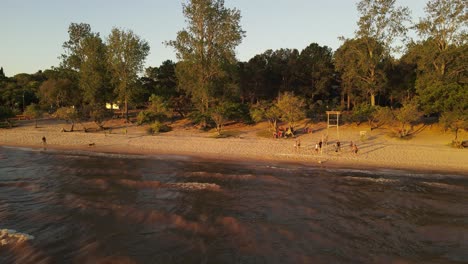 the coast of fray bentos in uruguay, where a group of friends play beach volleyball at sunset