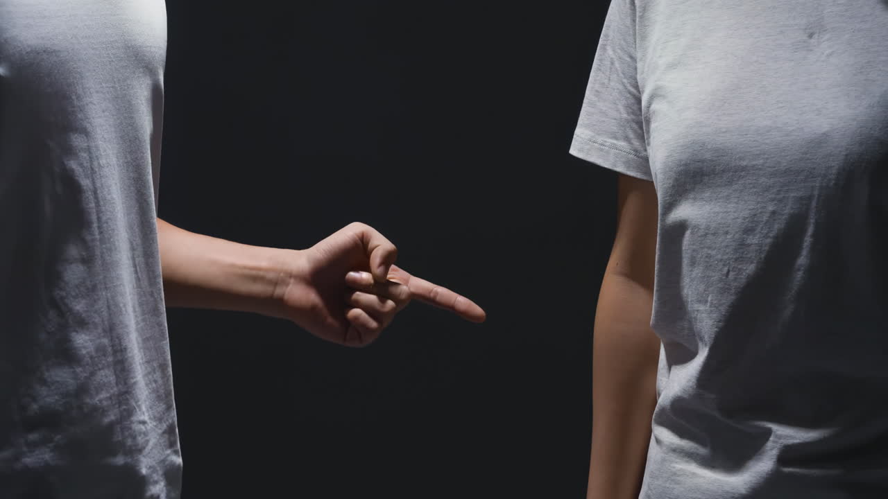 Coppia infelice, uomo e donna che litigano animatamente, si rimproverano, discutono, con accuse e lamentele, con espressioni affrante e arrabbiate in penombra, concetto di problemi di relazione e situazioni difficili di coppia.