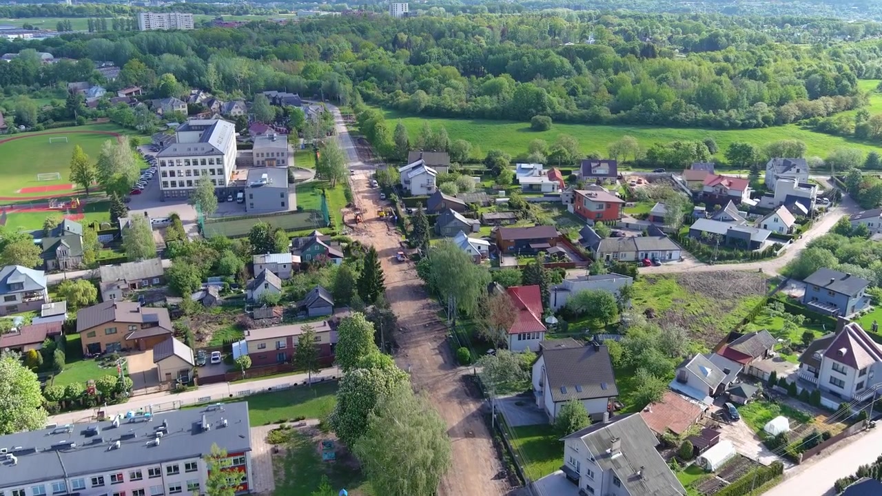 Luchtopname van de buitenwijken van Kaunas, omringd door vredige bossen en een schilderachtig landschap.