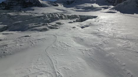 aerial push in: winter landscape, swiss alps mountain with a snow cover and a glacier