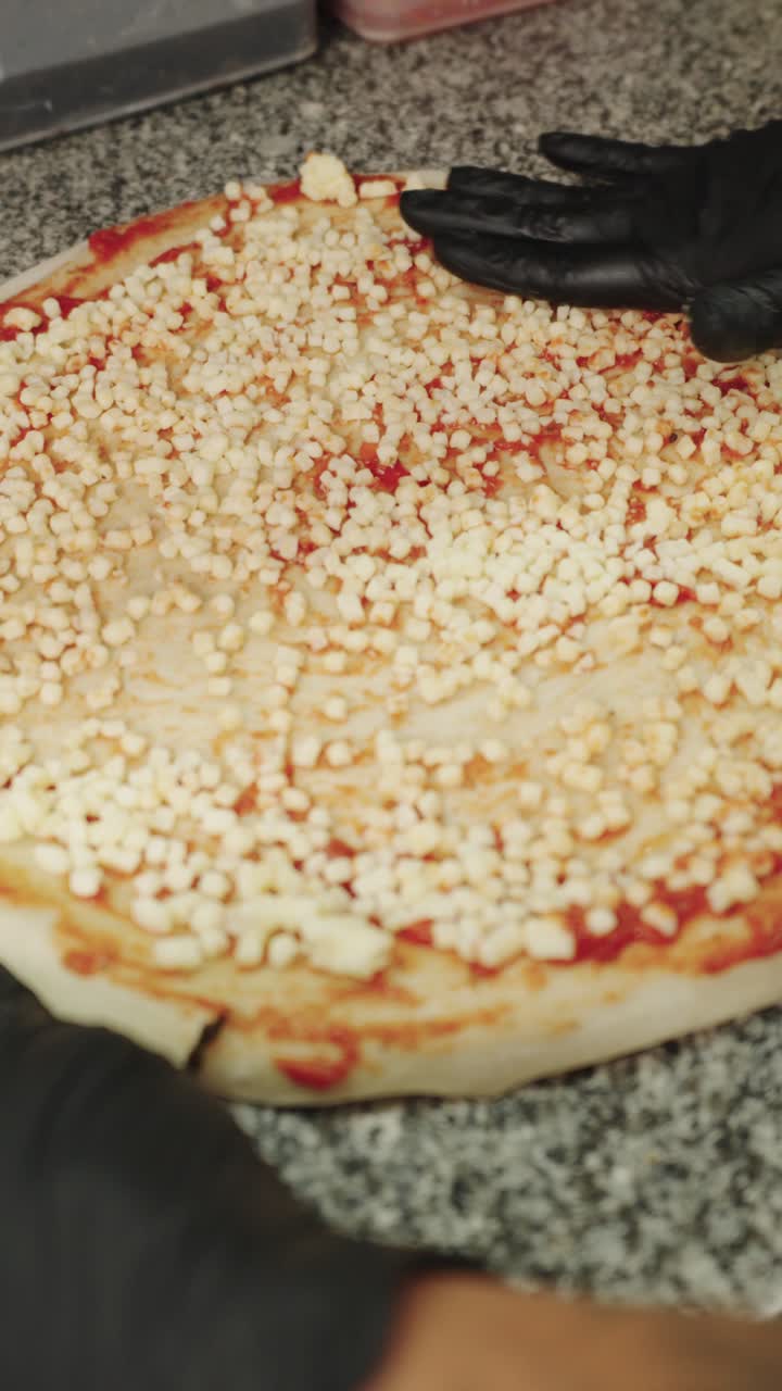 Making pizza with gloved hands