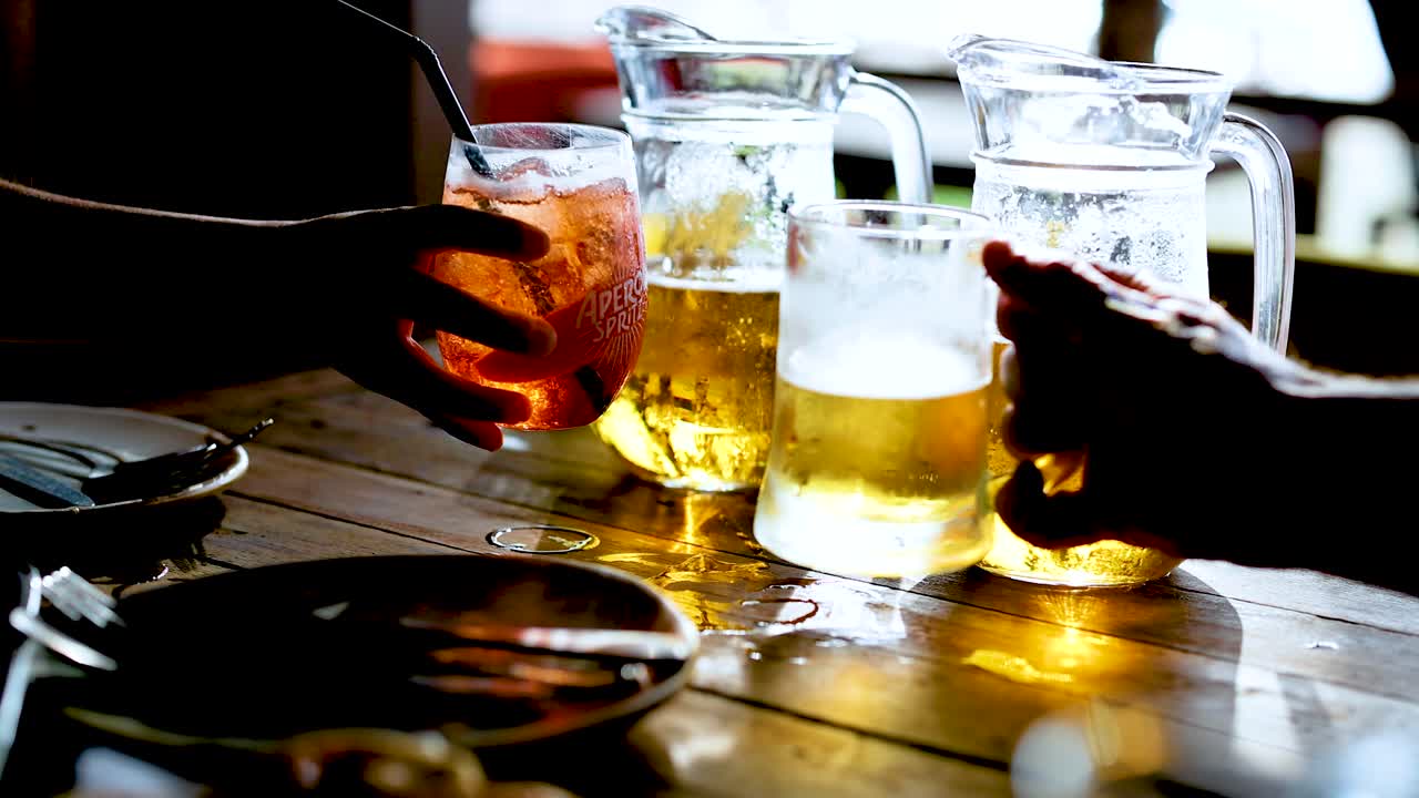 테이블 위 에 있는 음료 를 얻기 위해 손 을 는 것